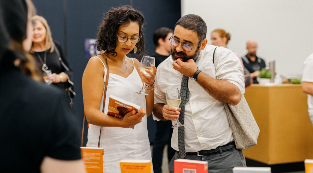 Two people looking at Duku's book